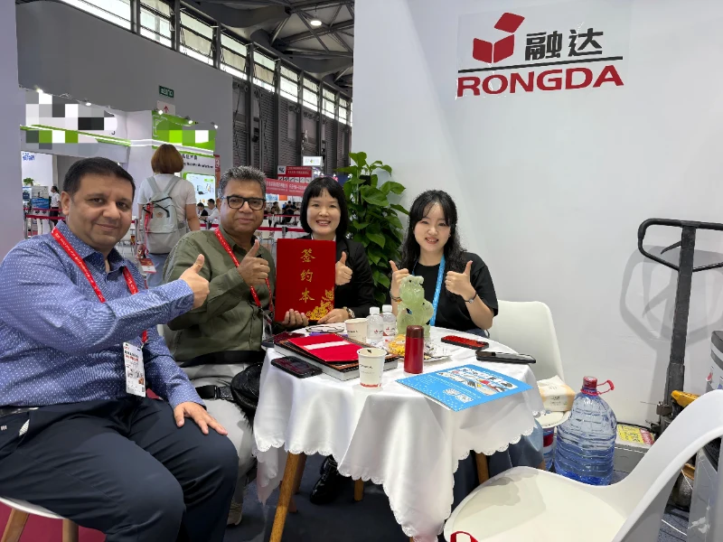 Rongda packaging equipment team takes photo with international customer at All in Print China exhibition